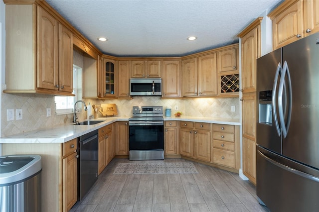 7 Bristol Dr, Palm Coast, FL 32137 - kitchen featuring stainless steel appliances, a sink, light wood-type flooring, glass insert cabinets, and recessed lighting