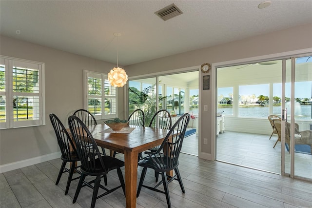 7 Bristol Dr, Palm Coast, FL 32137 - dining area with baseboards, healthy amount of natural light, a water view, and wood finished floors
