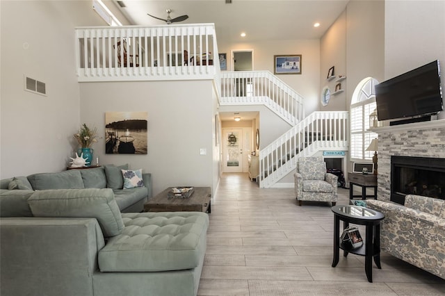 7 Bristol Dr, Palm Coast, FL 32137 - living room with a high ceiling, stairs, ceiling fan, wood finished floors, and a stone fireplace