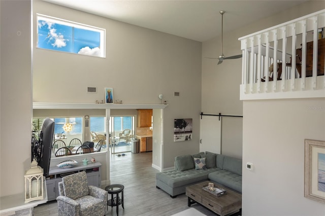 7 Bristol Dr, Palm Coast, FL 32137 - living room with a barn door, wood finished floors, a high ceiling, ceiling fan, and baseboards