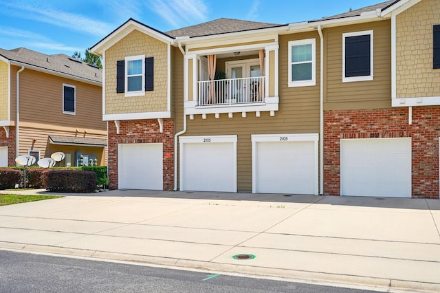 townhome / multi-family property featuring driveway, an attached garage, and brick siding