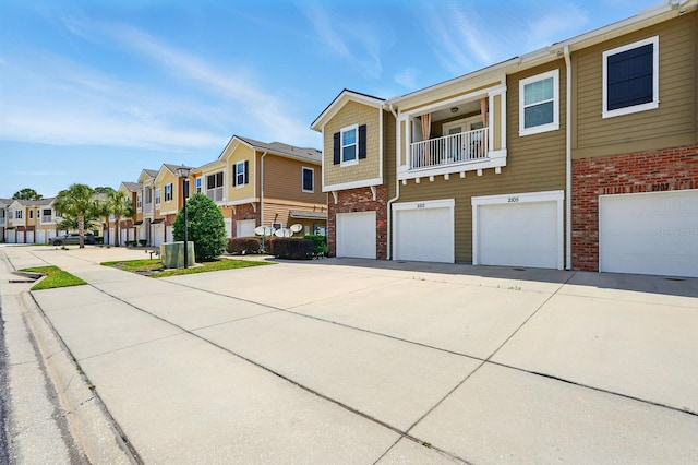 view of property with a residential view, brick siding, an attached garage, and concrete driveway