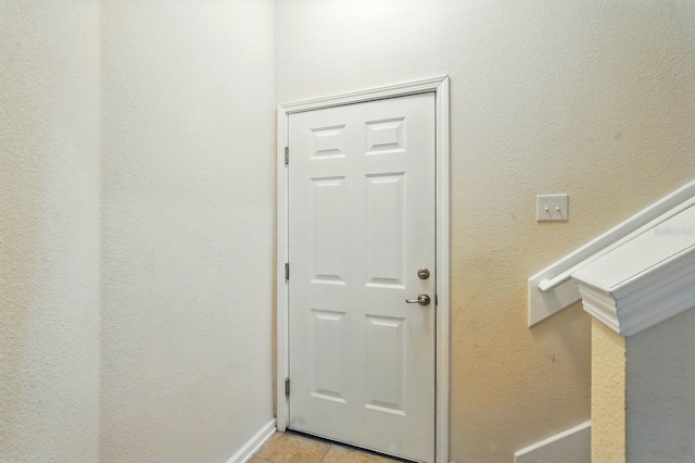 entryway with light tile patterned floors and baseboards