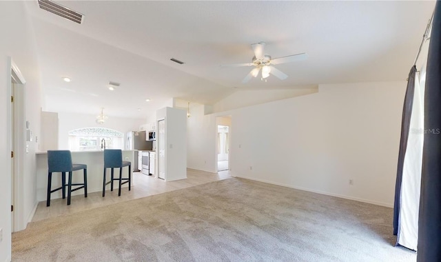 living room with light colored carpet, lofted ceiling, a ceiling fan, and baseboards