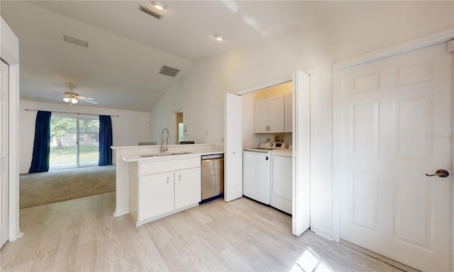 kitchen featuring dishwasher, a peninsula, independent washer and dryer, vaulted ceiling, and a sink
