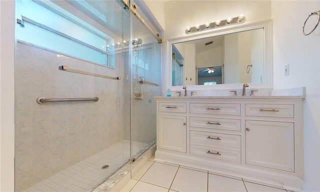 bathroom with tile patterned floors, a stall shower, ceiling fan, and double vanity