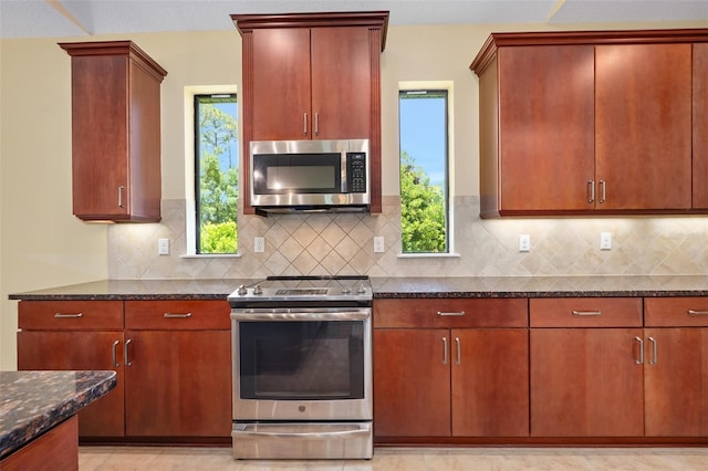 27 Bay Ct, Ormond Beach, FL 32174 - kitchen with stainless steel appliances, dark stone counters, and backsplash
