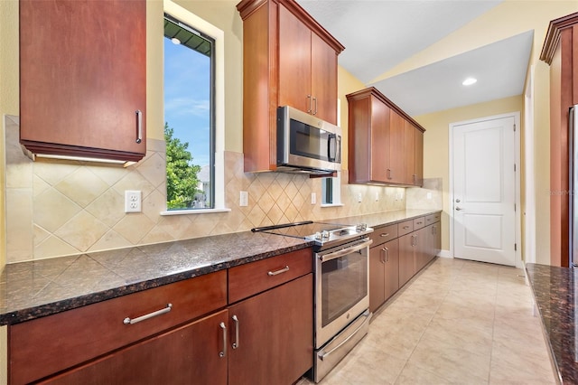 27 Bay Ct, Ormond Beach, FL 32174 - kitchen with stainless steel appliances, backsplash, lofted ceiling, and dark stone countertops