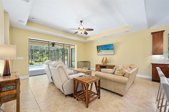 27 Bay Ct, Ormond Beach, FL 32174 - living area featuring a raised ceiling, ceiling fan, light tile patterned floors, and a sunroom