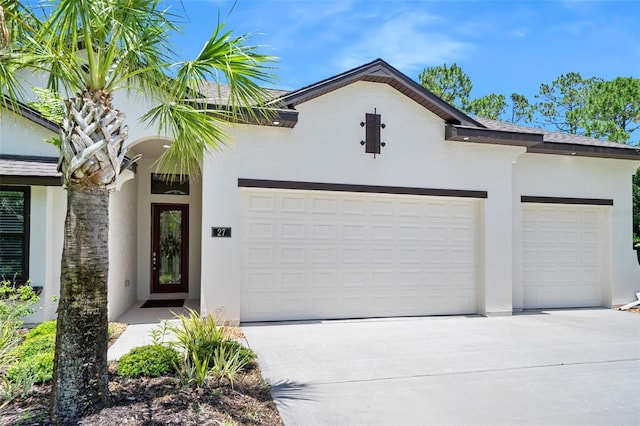 27 Bay Ct, Ormond Beach, FL 32174 - view of front of property with an attached garage, driveway, and stucco siding