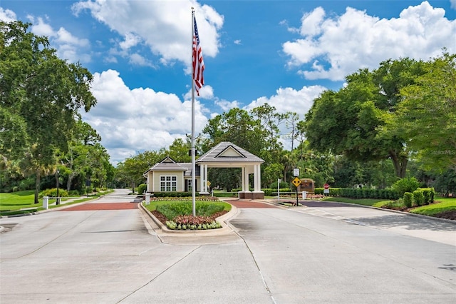 27 Bay Ct, Ormond Beach, FL 32174 - view of concrete road with traffic signs, curbs, and view of scattered trees