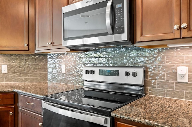 40 Oakleaf Way, Palm Coast, FL 32137 - kitchen featuring stainless steel appliances, tasteful backsplash, dark stone counters, and brown cabinetry
