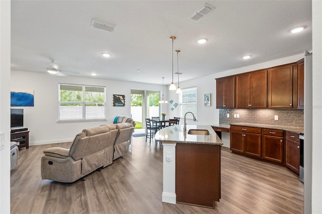 40 Oakleaf Way, Palm Coast, FL 32137 - kitchen featuring open floor plan, a sink, wood finished floors, light stone counters, and recessed lighting