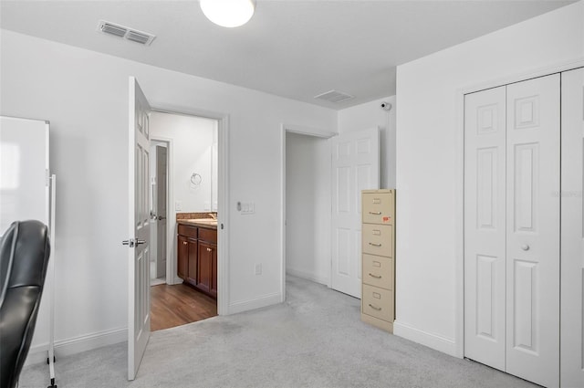 40 Oakleaf Way, Palm Coast, FL 32137 - bedroom featuring light colored carpet, a sink, baseboards, a closet, and connected bathroom