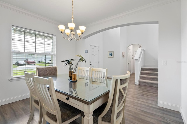 40 Oakleaf Way, Palm Coast, FL 32137 - dining area with a chandelier, crown molding, wood finished floors, arched walkways, and baseboards