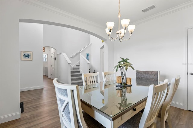 40 Oakleaf Way, Palm Coast, FL 32137 - dining space featuring arched walkways, a chandelier, wood finished floors, ornamental molding, and baseboards