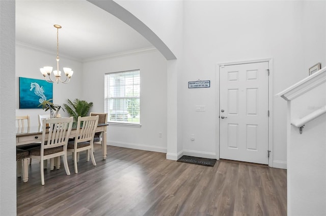40 Oakleaf Way, Palm Coast, FL 32137 - foyer entrance featuring wood finished floors, arched walkways, crown molding, a chandelier, and baseboards