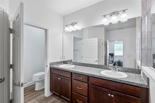 40 Oakleaf Way, Palm Coast, FL 32137 - full bath with double vanity, toilet, ensuite bath, and wood finished floors