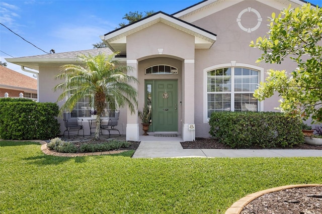 11 Roxboro Dr, Palm Coast, FL 32164 - property entrance with a yard and stucco siding