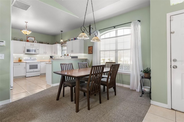 11 Roxboro Dr, Palm Coast, FL 32164 - dining room featuring light carpet, light tile patterned floors, baseboards, and vaulted ceiling