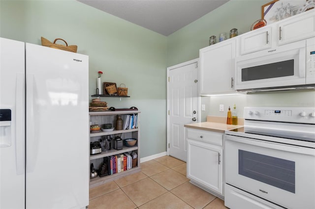 11 Roxboro Dr, Palm Coast, FL 32164 - kitchen with white appliances, white cabinetry, light tile patterned floors, and light countertops