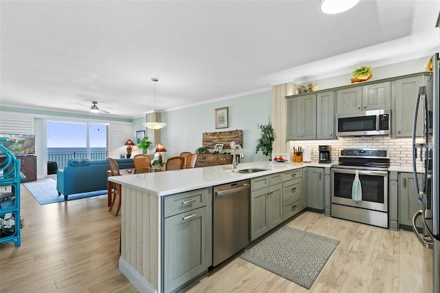 80 Surfview Dr Unit 721, Palm Coast, FL 32137 - kitchen featuring a peninsula, appliances with stainless steel finishes, a ceiling fan, light countertops, and ornamental molding