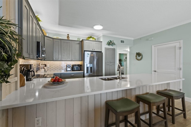 80 Surfview Dr Unit 721, Palm Coast, FL 32137 - kitchen with stainless steel appliances, tasteful backsplash, a kitchen breakfast bar, a peninsula, and ornamental molding