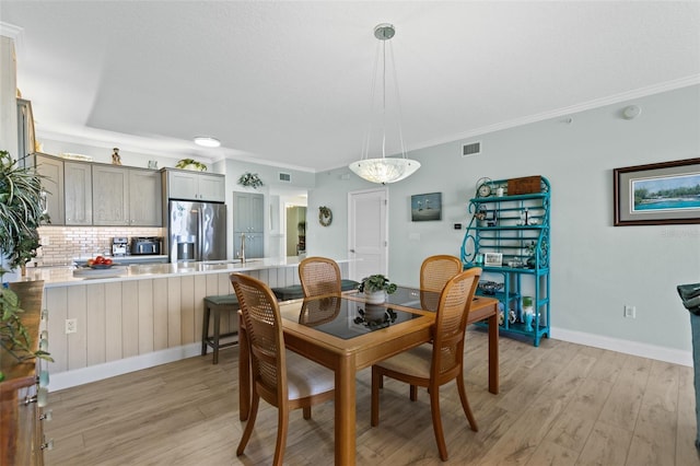 80 Surfview Dr Unit 721, Palm Coast, FL 32137 - dining room featuring light wood-type flooring and crown molding