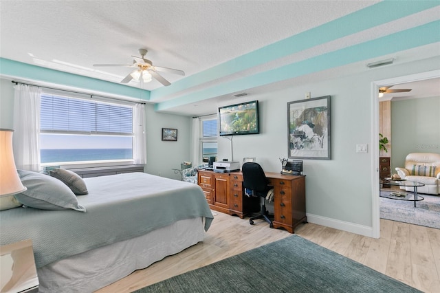 80 Surfview Dr Unit 721, Palm Coast, FL 32137 - bedroom with wood finished floors, a desk, a textured ceiling, and a ceiling fan