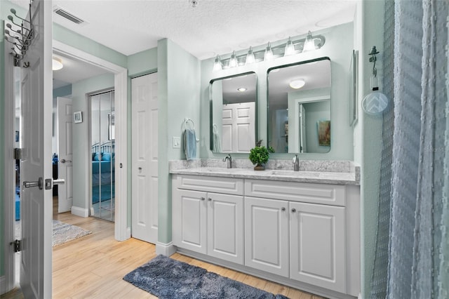 80 Surfview Dr Unit 721, Palm Coast, FL 32137 - bathroom with double vanity, wood finished floors, and a textured ceiling