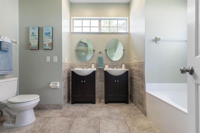 7 White Oak Ln, Palm Coast, FL 32164 - full bathroom featuring tile walls, toilet, wainscoting, a garden tub, and two vanities