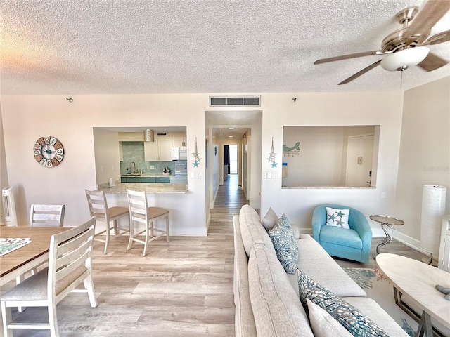1601 N Central Ave Unit G10, Flagler Beach, FL 32136 - living room featuring a textured ceiling, light wood-style flooring, and a ceiling fan