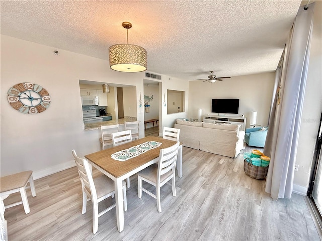 1601 N Central Ave Unit G10, Flagler Beach, FL 32136 - dining area featuring light wood-type flooring, a textured ceiling, ceiling fan, and baseboards
