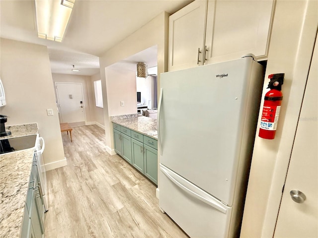 1601 N Central Ave Unit G10, Flagler Beach, FL 32136 - kitchen with freestanding refrigerator, green cabinetry, light wood finished floors, baseboards, and range with electric cooktop