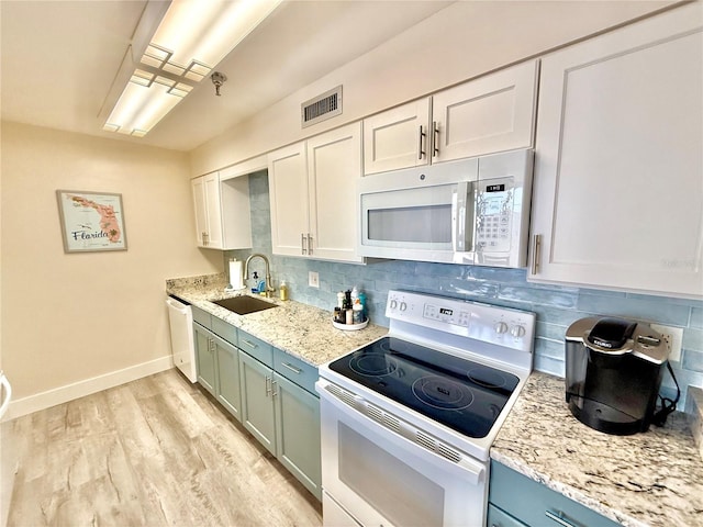 1601 N Central Ave Unit G10, Flagler Beach, FL 32136 - kitchen featuring white appliances, a sink, baseboards, backsplash, and light wood finished floors