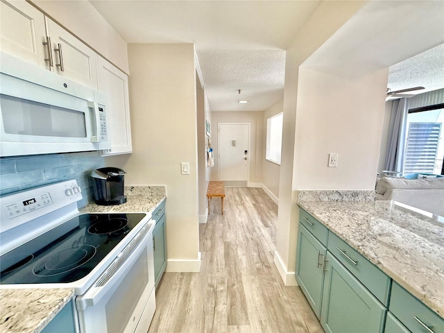 1601 N Central Ave Unit G10, Flagler Beach, FL 32136 - kitchen featuring white appliances, green cabinets, a textured ceiling, light wood-style flooring, and healthy amount of natural light