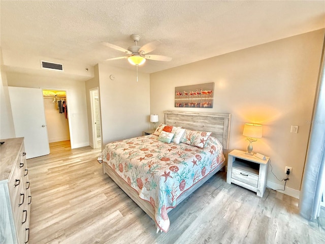 1601 N Central Ave Unit G10, Flagler Beach, FL 32136 - bedroom with light wood-style floors, a textured ceiling, baseboards, a spacious closet, and a ceiling fan