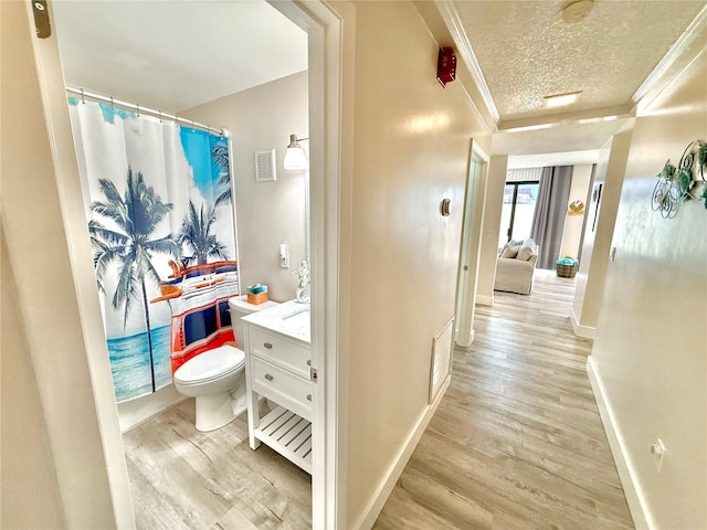 1601 N Central Ave Unit G10, Flagler Beach, FL 32136 - corridor featuring ornamental molding, light wood-type flooring, baseboards, and a textured ceiling