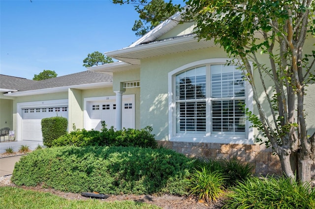 33 Veranda Way Unit 33, Palm Coast, FL 32137 - view of exterior entry with stucco siding, an attached garage, roof with shingles, and driveway