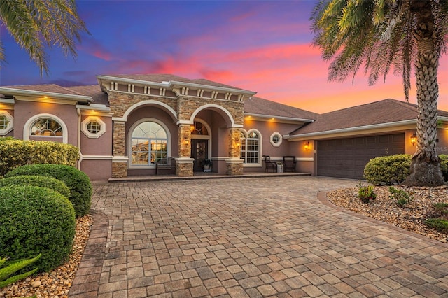 568 Luna Bella Ln, New Smyrna Beach, FL 32168 - mediterranean / spanish-style home with decorative driveway, stucco siding, a garage, and stone siding