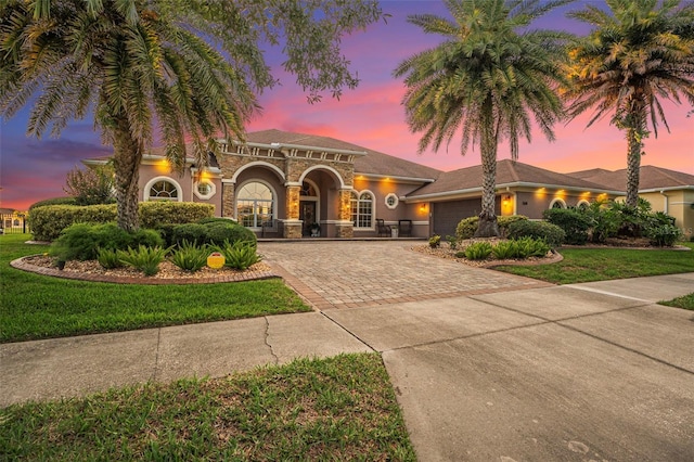 568 Luna Bella Ln, New Smyrna Beach, FL 32168 - mediterranean / spanish house with decorative driveway, a garage, stucco siding, and a front lawn
