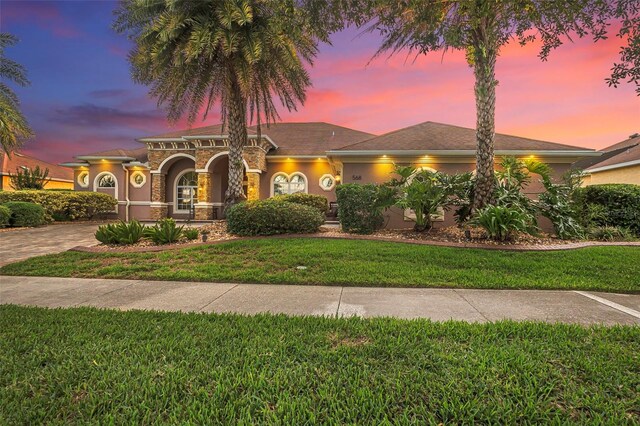 568 Luna Bella Ln, New Smyrna Beach, FL 32168 - view of front of property with a front lawn, stucco siding, decorative driveway, and stone siding