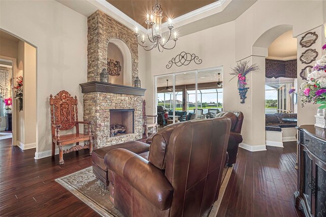 568 Luna Bella Ln, New Smyrna Beach, FL 32168 - living area featuring a fireplace, baseboards, a chandelier, dark wood-style flooring, and ornamental molding