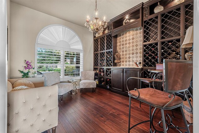 568 Luna Bella Ln, New Smyrna Beach, FL 32168 - wine area with dark wood finished floors, a chandelier, and a dry bar