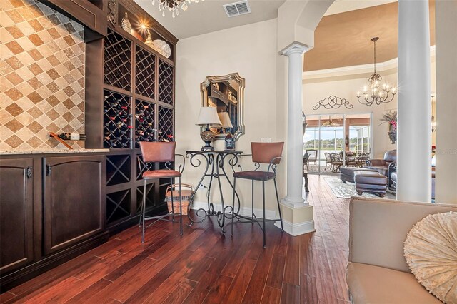 568 Luna Bella Ln, New Smyrna Beach, FL 32168 - wine area featuring decorative columns, dark wood-type flooring, baseboards, a chandelier, and crown molding