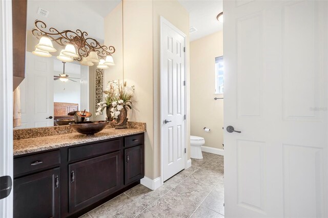 568 Luna Bella Ln, New Smyrna Beach, FL 32168 - bathroom with toilet, vanity, baseboards, ceiling fan, and tile patterned flooring