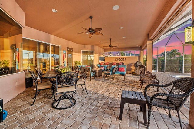 568 Luna Bella Ln, New Smyrna Beach, FL 32168 - patio terrace at dusk featuring a patio, a ceiling fan, a lanai, and outdoor dining space