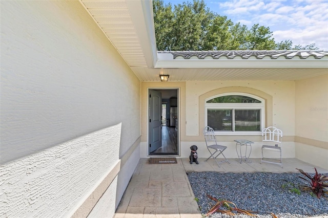 226 Pinegrove Dr, Palm Coast, FL 32164 - view of exterior entry with stucco siding, a patio area, and a tile roof