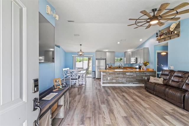 226 Pinegrove Dr, Palm Coast, FL 32164 - living room with vaulted ceiling, wood finished floors, and a ceiling fan