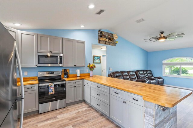 226 Pinegrove Dr, Palm Coast, FL 32164 - kitchen featuring stainless steel appliances, wooden counters, lofted ceiling, a peninsula, and gray cabinetry